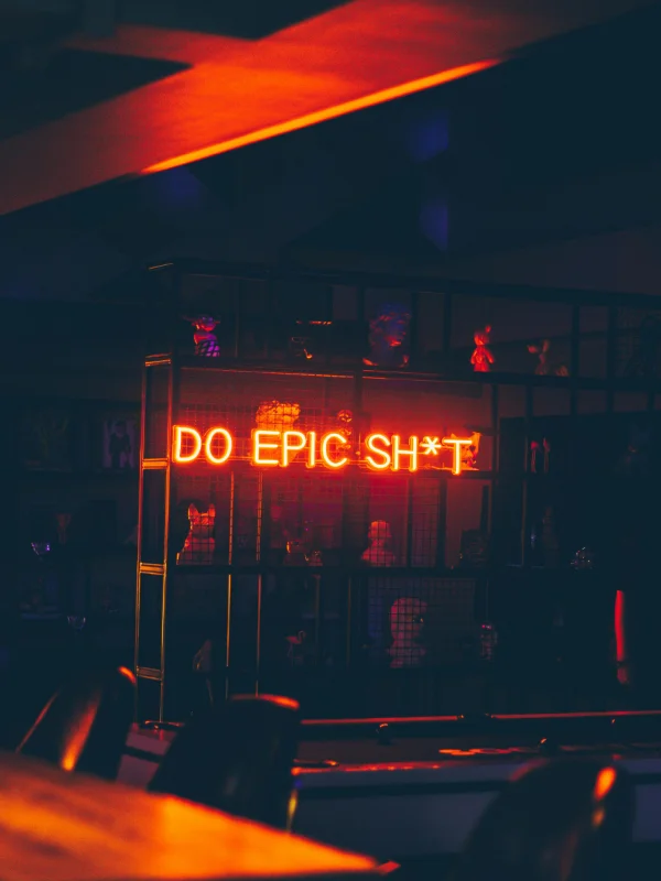 Ein stilvoller moderner Club mit einem auffälligen Neon-Schriftzug ‚Do Epic Sh*t‘ – genau die Art von Ambiente, die neue Betreiber berücksichtigen sollten, wenn sie einen Swingerclub kaufen und erfolgreich führen möchten.