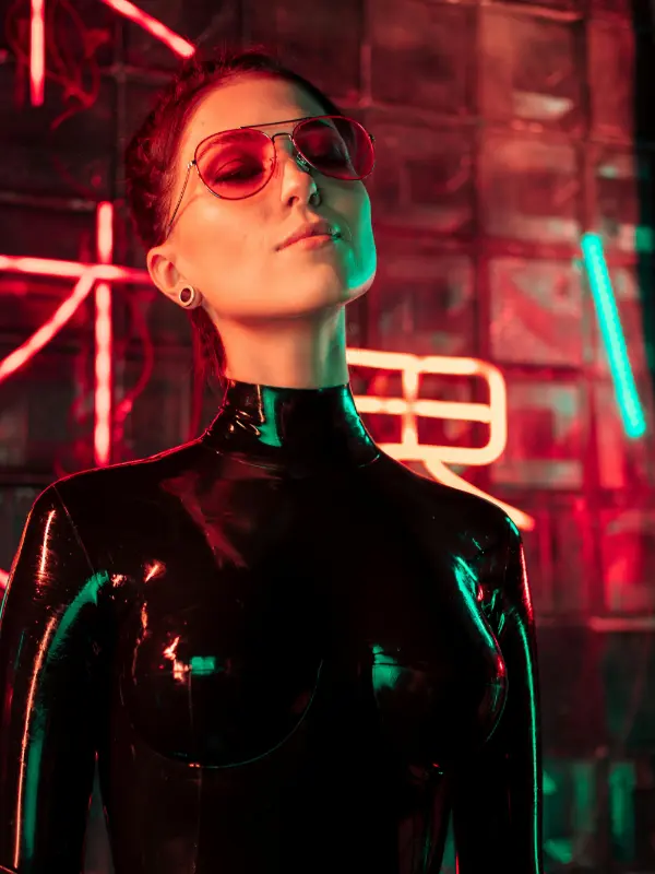Frau im Latex-Outfit vor Neonlichtern – Symbol für BDSM-Szene