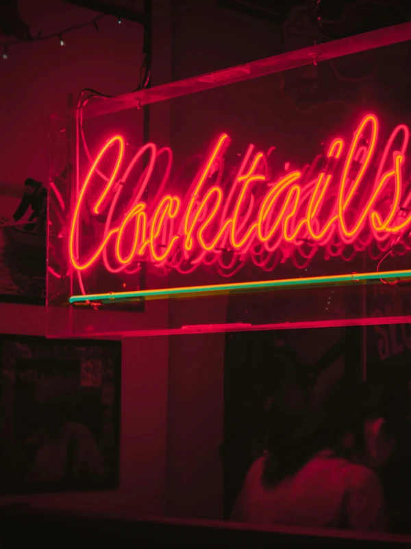 Neon-Schild mit Schriftzug „Cocktails“, Symbol für Branding-Fehler bei der Swingerclub-Gründung