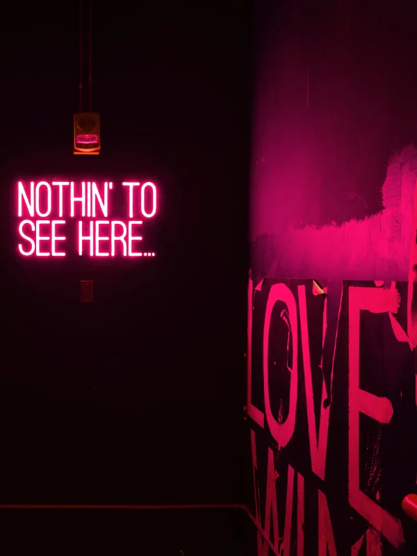 Neon-Schriftzug in dunkler Umgebung – geheimnisvolle Pornokino-Atmosphäre