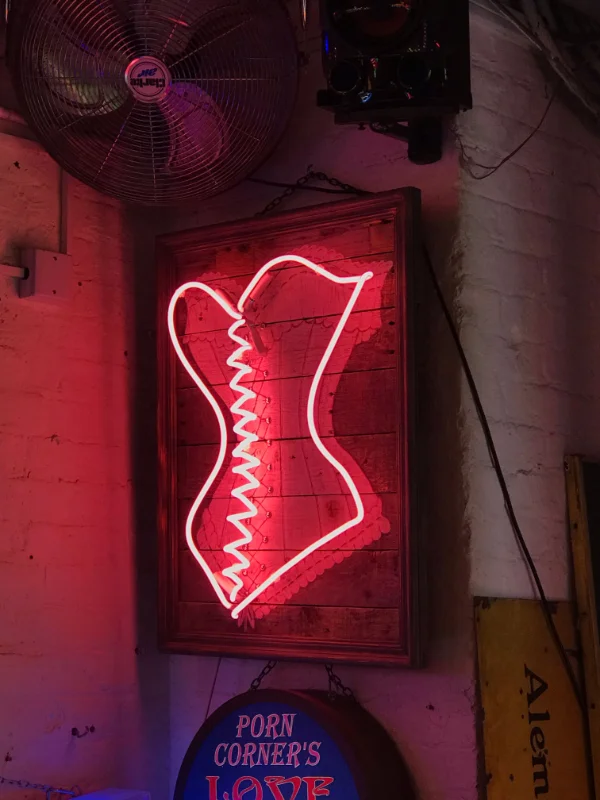 Neonkorsett-Schild an Backsteinwand als Symbol für die Erotikbranche