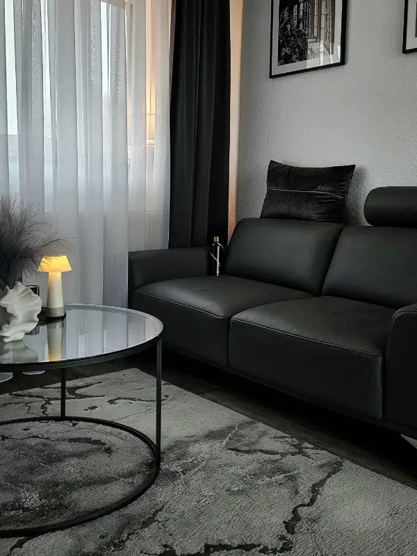 Wohnbereich: dunkles Sofa mit edler Wohnzimmereinrichtung