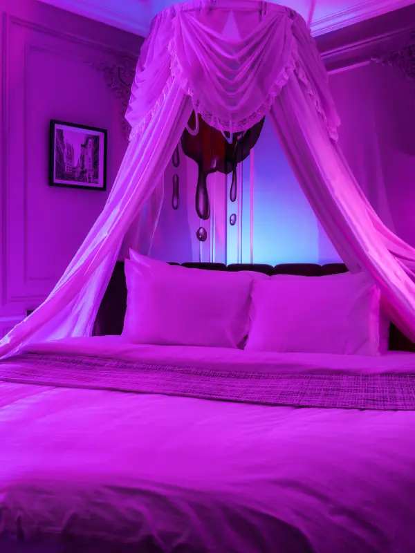 Stimmungsvoll beleuchtetes Zimmer mit Himmelbett