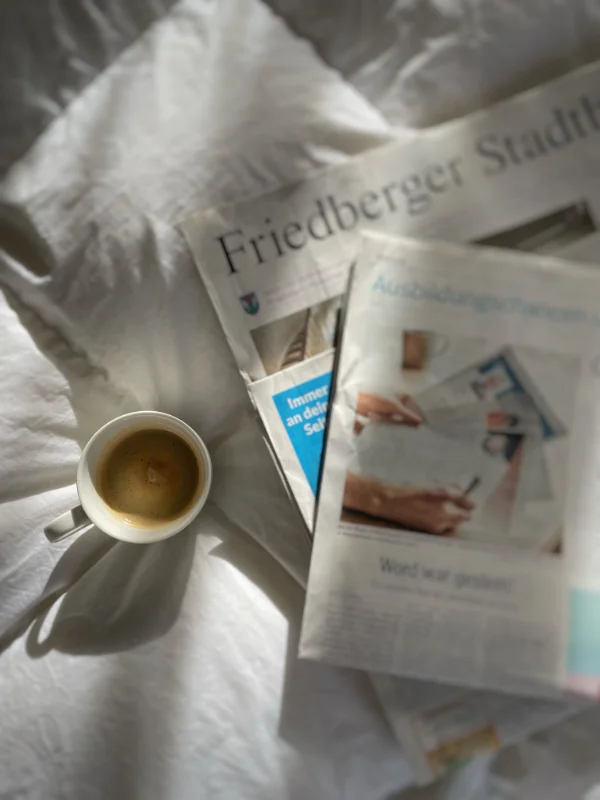 Lokale Tageszeitung liegt neben einer Kaffeetasse