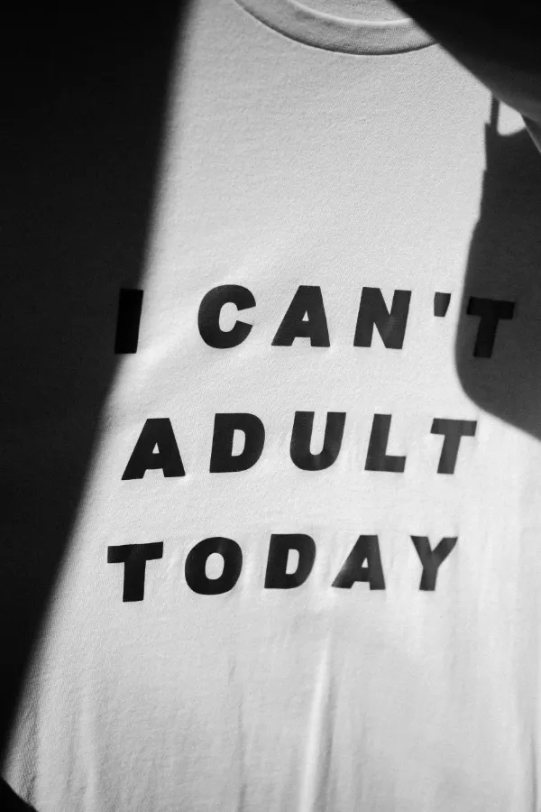 Weißes T-Shirt mit dem Schriftzug „I can't adult today" im Licht- und Schattenspiel