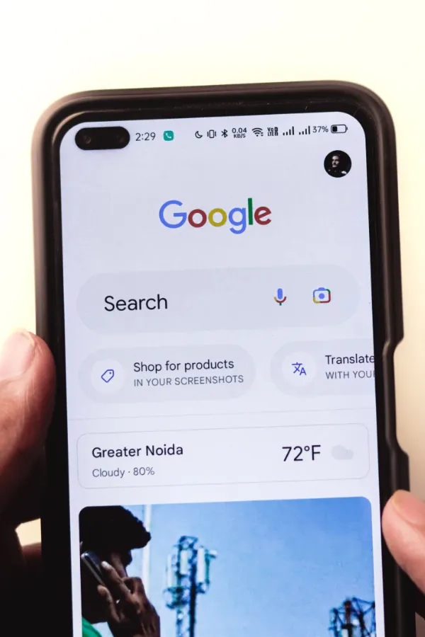 Hand hält ein Smartphone mit geöffneter Google-Suche